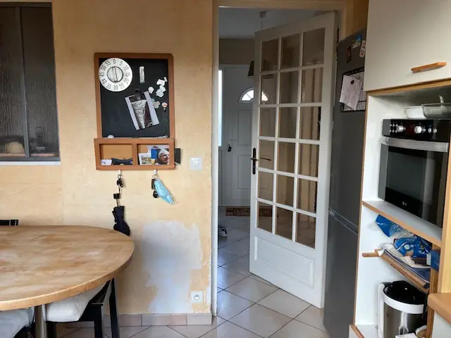 Vue de l'ancienne cuisine vers l'entrée, mur avant démolition